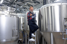Factory Worker Checking The Tanks With Beer And Looking Satisfied With The Result