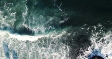 Ocean Surge Aerial Of Slow Moving Emerald Wave Crashing Into Rocky Outcrop Along The California Coas