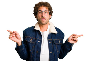 Poster - Young curly smart caucasian man cut out isolated pointing to different copy spaces, choosing one of them, showing with finger.