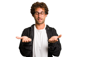 Wall Mural - Young curly smart caucasian man cut out isolated holding something with palms, offering to camera.