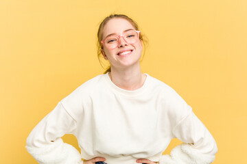 Wall Mural - Young caucasian redhead woman isolated on yellow background happy, smiling and cheerful.