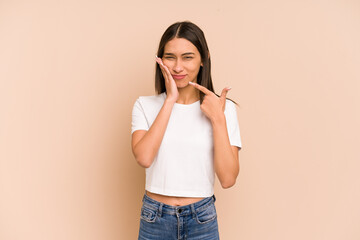 Young colombian woman isolated on beige background having a strong teeth pain, molar ache.