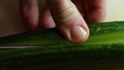 Poster - hand with knife cuts cucumber on board