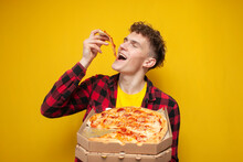 Curly Guy Eating Pizza On Yellow Background, Hungry Student Enjoy Fast Food