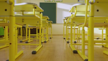 Aufkleber - School empty classroom with white and green blackboard, educational yellow desks and chairs for studying lessons elementary school. Interior of children's education, educational concept for children