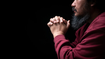 Wall Mural - Hands folded in prayer on in church concept for faith, spirituality and religion, man praying in the morning. man hand with praying god. Person Christian men who have faith in Jesus worship in dark.