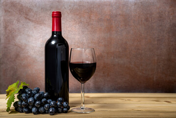 Wall Mural - Red wine and grapes on wooden background