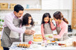 © Art_Photo - Portrait of enjoy happy love asian family father and mother with little asian girl daughter child play and having fun cooking food together with baking cookie and cake ingredient in kitchen