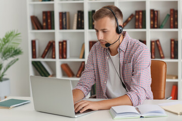 Poster - Young man with headset and laptop studying online at home