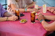 © Ladanifer - Unrecognizable mature adults drinking and eating olives together at a restaurant. Anonymous group of people at a bar.