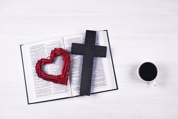 Wall Mural - An open Bible on the table. The cross and heart are a symbol of God's love for people. Prayer