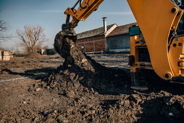 Wall Mural - Close up of a earthmover digging soil on construction site.