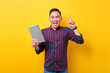 © Sewupari Studio - Excited young Asian man holding digital tablet and raising finger up, having good idea isolated over yellow background
