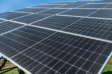 Solar panel reflecting the sun and cloudy blue sky in the background.