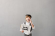 © Sunny studio - Newsboy shouting against grunge wall background. Boy selling fake news