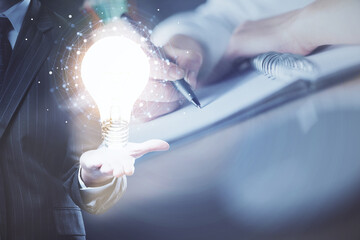 Poster - Drawing bulb over woman's hands taking notes background. Concept of idea. Double exposure