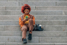 Afro American Girl On The Stairs In The Street With Mobile Phone