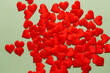 Green background with red hearts for Valentine's day. Red hearts on a bright green background. Inspired by love and passion. 