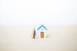 © sirirak - Miniature old man holding grocery bag with miniature house with space on blurred background, retirement home, elderly care service concept
