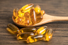 Fish Oil Omega 3 Capsules Vitamin With EPA And DHA Isolated On Wooden Background.