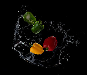 Wall Mural - water splash on sweet pepper isolated on black