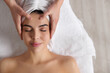 © New Africa - Beautiful woman receiving facial massage in beauty salon, closeup. Top view
