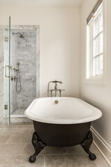 Wall Mural - Matte Black Stand Alone Tub in En Suite Bathroom. Soaking tub with stand alone shower with glass door. Gray bathroom tile with metallic fixtures.