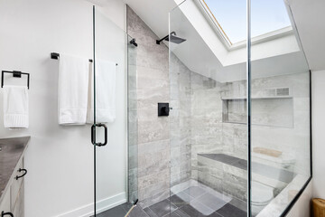 Modern and Bright Primary Bathroom with Walk In Shower. Enclosed glass shower with rainfall shower head and skylight. 