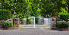 Double Wrought-iron Gate. Wrought Iron Gate And Stone Pillar. White Wrought Iron Entrance Gates To Rural Property