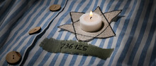 David Star And Burning Candle On Prisoner Robe. International Holocaust Remembrance Day