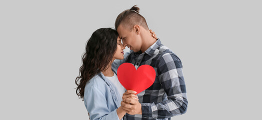 Wall Mural - Loving couple with paper heart on light background