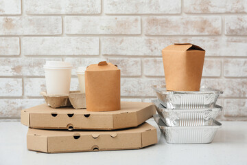 Sticker - Set of food delivery containers on white table near light brick wall