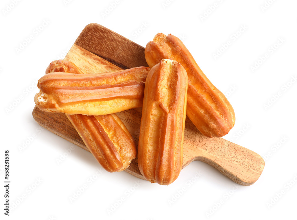 Wooden cutting board with delicious eclairs on white background