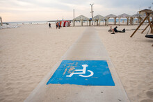 Disability Sign And Path Road For Wheel Chair On The Sea Beach. Sand Beach Places For People With Disabilities.