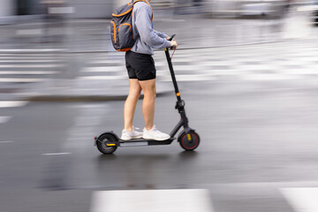 Wall Mural - motion blur picture of a person with an electric scooter on a city street