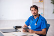 © Elnur - Young male doctor working in the clinic