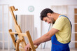 © Elnur - Young male repairman repairing easel at home