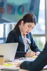 Wall Mural - Millennial Asian young professional successful  businesswoman in formal suit with female and male businessman colleague in formal suit brainstorming  in company office room.