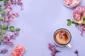 Wall Mural - Lilac flowers with cup of tea on colourful background.