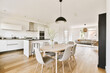 © Casa imágenes - a kitchen, dining room and living area in an apartment with white walls and wood flooring the table is surrounded by grey chairs