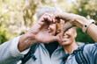 Heart, love hands and senior couple outdoors on vacation, holiday or hiking trip. Affection sign, romance emoji and elderly interracial couple, man and woman bonding together in nature on a hike.