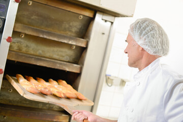 Wall Mural - Taking bread out of the oven