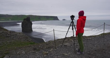 Wall Mural - Iceland landscape travel photographer and tourist photographing nature on Iceland in Dyrholaey with view of Reynisfjara beach by Vik, South Iceland. SLOW MOTION