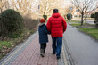 © AS Photo Family - Back of grandfather with grandson walking at pathway in a park.