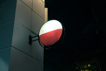 Wall Mural - Illuminated empty signboard hanging on edge of store building in the night