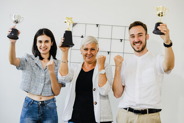 Wall Mural - businessman team holding award trophy for show their victory. we are the champions! successful busin