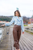 Fototapeta Londyn - Portrait of young woman walking along the river in the city, lifestyle concept, blue shirt
