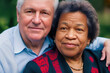 © Frank - Older happy-looking couple of a white man with a blue shirt and white hair and a black woman with many wrinkles, fictional person, made with generative AI