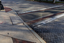 Sunlight And Shadows On A Multi Texture Street Surface With Asphalt, Brick, Paint In Multiple Colors And Patterns, Horizontal Aspect