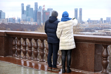 Wall Mural - Couple of tourists looking the panorama and skyscrapers of Moscow city. Winter travel in Russia or buying real estate